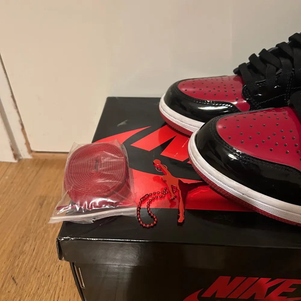 Säljer ett par snygga Nike Air Jordans1 i svart och rött. Skorna är använda två tre gånger och kommer med extra röda skosnören. . Skor.