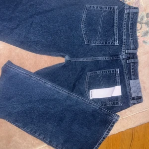 Blå jeans från Collusion - Säljer ett par snygga blå jeans från Collusion i storlek 28/34. De har en klassisk design med fem fickor. Perfekta för vardagsbruk och kan enkelt matchas med olika outfits. Passar både till skolan och fritiden! Jeansen är lågmidjade.