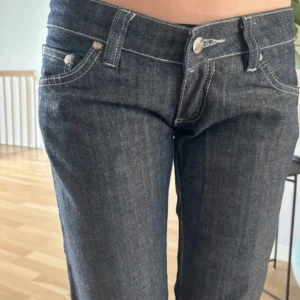 Mörkblå jeans från G-Star RAW - Säljer ett par snygga mörkblå jeans från G-Star RAW. De har en låg midja och en straight passform. Jeansen är i bra skick och har en cool dragkedjedetalj på bakfickan med G-Star RAW-loggan. Perfekta för både vardag och fest!
