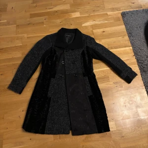 Svart och grå kappa från Petroff - Säljer en elegant svart och grå kappa från Petroff i storlek 42. Den har en stilren design med knappar framtill och en mjuk krage. Perfekt för höst och vinter, håller dig varm och snygg! 🖤