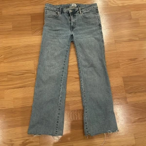 Blå jeans med rå kant - Säljer ett par klassiska blå jeans i bra skick. De har en straight passform och är högmidjade. Jeansen har en cool rå kant nertill som ger en avslappnad look. Perfekta för både vardag och fest!