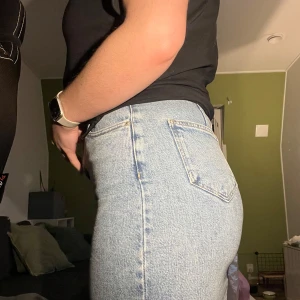 Blå jeanskjol från ASOS Design - Säljer en snygg blå jeanskjol från ASOS Design i storlek EU 36. Kjolen är högmidjad och har en klassisk denimlook. Perfekt för både vardag och fest! 🦋Den har en slits och två bakfickor