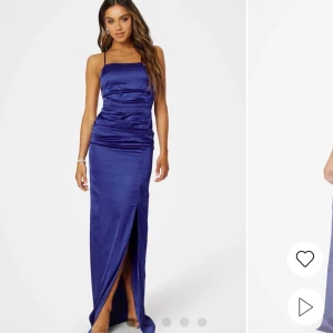 Blå långklänning med slits - Elegant blå långklänning i satin med smala axelband och öppen rygg. Klänningen har en stilren slits framtill och snörning i ryggen för en perfekt passform. Klänningen har används en gång till balen. Skriv privat för mer bilder