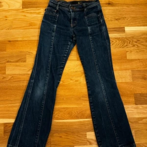 Mörkblå jeans med vida ben - Snygga mörkblå jeans med vida ben och klassisk femficksdesign. De har en knapp och dragkedja framtill. Perfekta för en avslappnad stil.