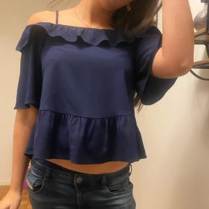 Mörkblå offshoulder topp⭐️💙 - Säljer en snygg mörkblå offshoulder topp med volangdetaljer. Toppen har korta ärmar och en luftig passform, perfekt för en fest eller fin middag.💕 Passar S