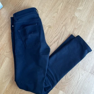 Svarta Nudie Jeans - Snygga svarta jeans från Nudie Jeans med klassisk femficksdesign och knappgylf. Perfekta för en stilren look. Tillverkade i ett slitstarkt material som ger en bekväm passform.