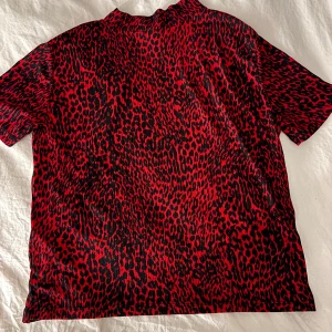 Röd och svart leopardmönstrad topp från Zara - Snygg röd och svart leopardmönstrad topp från Zara. Toppen har korta ärmar och en normal passform.