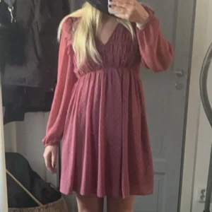 Super söt klänning - Charmig röd klänning från Zara med v-ringning och långa ärmar. Klänningen har en smickrande passform med volangdetaljer och ett lätt transparent material som ger en luftig känsla.