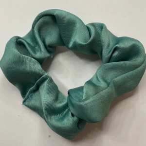 Turkos scrunchie i satin - Snygg och stilren turkos scrunchie i satinmaterial. Perfekt för att sätta upp håret eller som en trendig accessoar runt handleden. Den mjuka satintexturen ger en lyxig känsla och skonsam passform. Produkten kommer även med freebies!