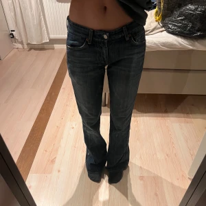 Blå jeans från 7 for All Mankind - Snygga blå jeans med bootcut-stil från 7 for All Mankind. De har en låg midja och coola broderade detaljer på bakfickorna. Perfekta för en avslappnad look. Jag är ca 167 cm lång 