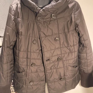 Brun quiltad jacka från Mexx - Säljer en jätte fin brun quiltad jacka från Mexx med dubbelknäppning. Jackan är ribbade vid händerna. Perfekt för kyligare dagar.💞