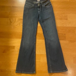 Blå lågmidjade bootcut jeans från Nelly - Super Snygga blå lågmidjade bootcut jeans med vita detaljer ifrån nelly. Storlek 40. Inga defekter eller fläckar.