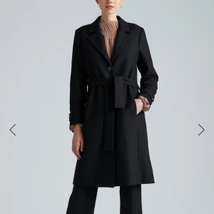 Svart kappa från InWear - Snygg klassisk svart kappa från InWear med knytbälte i midjan och quiltat foder. Stl 36 och har ca 50% ull i yttermaterialet. Den har legat nerpackad i en flyttlåda och tyget har blivit lite skrynkligt (se bild 3) men det går nog styrka/steama den slätt igen men har ej testat. En knapp i fram är lite lös men det är bara att sy fast den igen.  Mer bilder går att få vid intresse 🌸