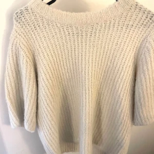 Vit kortärmad stickad tröja.  - Mysig vit stickad tröja med korta ärmar. Nyskick. 