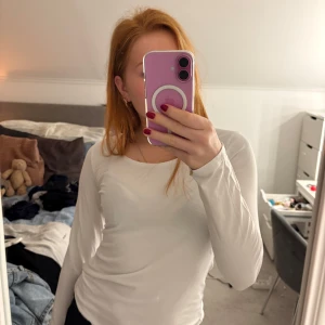 Vit långärmad topp från Lindex - Säljer en stilren vit långärmad topp från Lindex. Perfekt basplagg med rund halsringning, tillverkad i mjuk bomull för en bekväm passform. Ett måste i garderoben för alla säsonger.