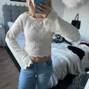 Vit spetsmönstrad tröja från H&M - Säljer en söt vit spetsmönstrad tröja från H&M. Tröjan är croppad med långa ärmar och har en vågig kant vid nederdelen. Perfekt för en stilren och romantisk look. Köpt på barnavdelningen men passar mig som är en S!
