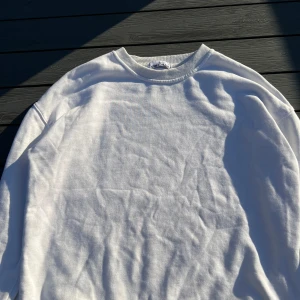 Vit tröja från Stone Island - Säljer en stilren vit tröja från Stone Island. Den är långärmad och har en klassisk passform. Perfekt för både vardag och lite mer avslappnade tillfällen. Tröjan är äkta det finns qr-kod, inga skador och tröja passar som en storlek M.