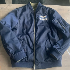 Ralph louren jacka - En fin Ralph louren jacka i fint skick, orginalpris: ca 2500kr Mitt pris: osäker men kom med bud Är en bomber jacka som kan vändas ut och in och användas på båda hållen/färgerna och passar mig som är 180