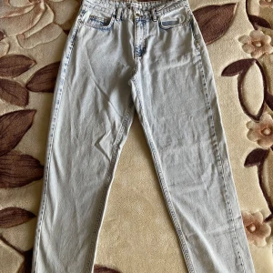 Nya urtvättade ljusblåa jeans  - Nya och oanvända - saknar prislapp! Byxorna har raka ben och är urtvättade i ljusblå färg (framgår tydligare på bild 5). Ingen stretch, hög midja.  MÅTT Midja: 38,5cm Innerbenslängd: 76cm Höfter: 54cm Totallängd: 108cm  100% bomull Nypris: 199 kr