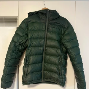 Grön peak performance jacka  - Bra skick med en liten skada på ryggen.