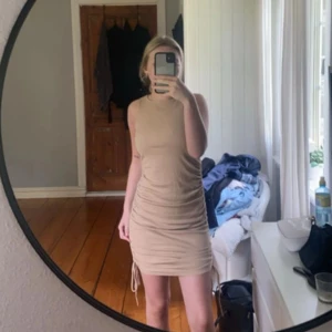 Beige klänning från H&M - Beige klänning från H&M, man kan reglera längden på klänningen med snörning på sidorna. Storlek XS, använd två gånger💕