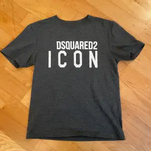 Säljer en snygg grå t-shirt från Dsquared2. T-shirten är i okej skick och passar för ungdomar i åldern 11-12 år, är runt 140-150cm, ny pris runt 1000kr.