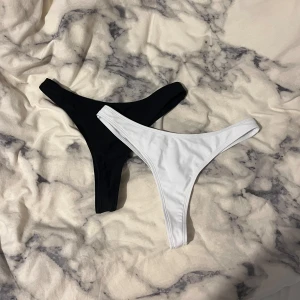Bikini underdelar, vit & svart - Säljer mina två oanvända bikini underdelar då de var lite stora på mig. Storlek S och en perfekt modell (åt string hållet men visar inte heller för mycket)!