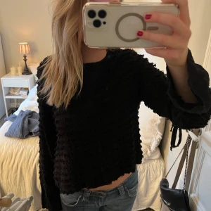 Svart blus som är öppen i ryggen  - Svart blus som är öppen i ryggen. Köpt utomlands så är osäker på märke och storlek, men den passar utmärkt på mig som i vanliga fall är en S!! Volang ärmar med knyten. Även knyten i bak. Älskar!! Super festlig🥰🥰🥰