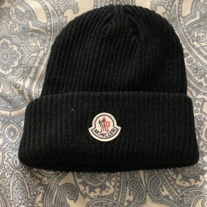 Moncler mössa - En svart moncler mössa. Använt bara några gånger. Den jätte ren
