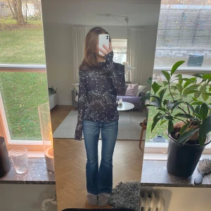 Svart blommig blus - Säljer en snygg svart blus med blommigt mönster. Blusen har långa ärmar och en luftig passform, perfekt för både vardag och fest. Passar bra till jeans eller kjol för en stilren look 🩷