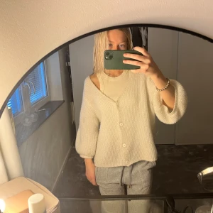stickad kofta - Mysig beige stickad kofta med knappar framtill. Den har en loose passform och trekvartsärmar, perfekt för höst och vår. Koftan är i bra skick och passar till både vardag och fest. Enkelt att matcha med olika outfits! Har dock lite defekter, se sista bilden