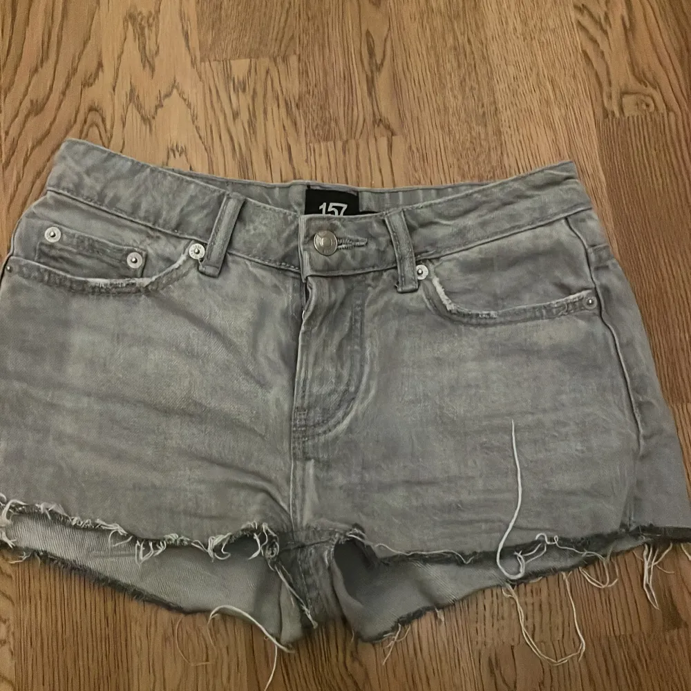 Säljer ett par grå jeansshorts från 157 i storlek XXS. De har en cool, fransig kant och en klassisk femficksdesign. Perfekta för sommardagar eller festivaler! 🕶️. Shorts.