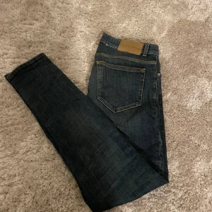 Tiger of Sweden jeans - Säljer ett par snygga mörkblå jeans från Tiger of Sweden i modellen Evolve. De är i bra skick samt att dom är använda några gånger. Storlek 29-32, Nypris 1599, tveka inte på att höra sv dig vid frågor och funderingar.
