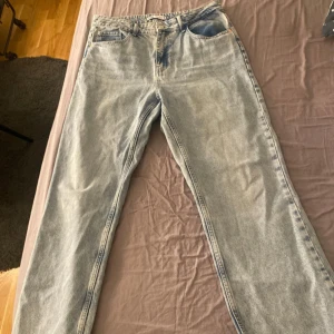 Ljusblå jeans från Zara - Säljer ett par ljusblå jeans från Zara i bra skick. De har en klassisk femficksdesign och en knappgylf. Perfekta för en avslappnad vardagslook!