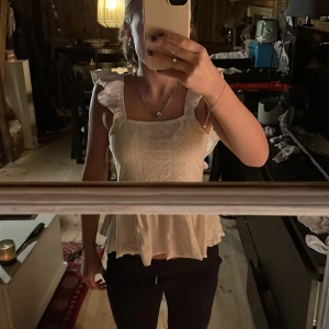 Vit topp från Shein - Säljer en söt vit topp från Shein i storlek XS. Toppen har volangdetaljer och en öppen rygg med knytning. Perfekt för sommardagar eller en festlig kväll. Den är i mycket bra skick och har ett fint broderat mönster.