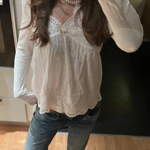 Vit blus med spetsdetaljer - Säljer en superfin vit blus med spetsdetaljer och långärmad design. Perfekt för både vardag och fest! 💗 Från odd molly i storlek S 