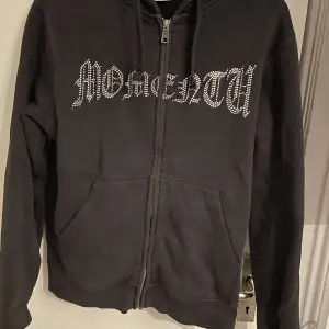 Säljer en svart hoodie med dragkedja och  glittriga stenar på framsidan. Den har en klassisk passform med långa ärmar och en bekväm huva. Perfekt för en avslappnad stil eller en cool vardagslook. Säljer för att den har blivit för liten, om ni har några funderingar är de bara att skriva ✍️ ,lägg gärna prisförslag😊