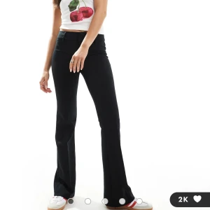 Svarta byxor från Bershka - Säljer ett par svarta soft flare byxor från Bershka i storlek 34. De är lågmidjande och har en snygg bootcut-stil som ger en trendig look. Perfekta för både vardag och fest!