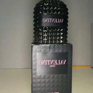 Valentino Uomo Parfym 100ml - Säljer en lyxig Valentino Uomo parfym i en snygg, mörk flaska med ett unikt, geometriskt mönster. Flaskan har en elegant och maskulin design som verkligen sticker ut. Perfekt för den som vill ha en sofistikerad doft med stil. Flaskan är nästan full och kommer med originalförpackning. Använt Max 8 sprays.