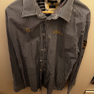 Rutig skjorta från Redgreen - Säljer en snygg rutig skjorta från Redgreen i storlek XXL. Skjortan är i mycket bra skick och har ett klassiskt rutmönster i svart och vitt. Den har långa ärmar och knappar framtill. Perfekt för både vardag och fest! 🎉