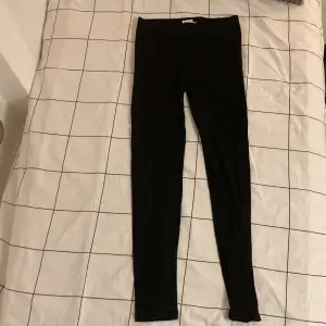 Säljer ett par svarta leggings i bra skick. De är tighta och perfekta för både vardag och träning. Materialet är mjukt och stretchigt, vilket gör dem superbekväma att ha på sig. Passar perfekt till en oversized tröja eller en snygg topp.