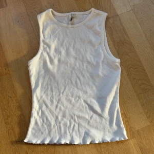 Vit ribbad linnetopp från Nelly  - Säljer en superfin vit ribbad linnetopp från Nelly Trend i storlek XS. Perfekt som ett basplagg i garderoben. Toppen är ärmlös och har en skön passform. Materialet är en blandning av bomull och polyester vilket gör den både mjuk och hållbar. 🤍