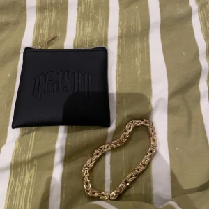 Guldarmband med svart förvaringsväska - Säljer ett snyggt guldarmband som kommer med en stilren svart förvaringsväska med texten 'KEJSAR'. Armbandet har en flätad design och är perfekt för att ge en touch av elegans till din outfit. Perfekt för både vardag och fest! Har köpt den för 1699 kr 