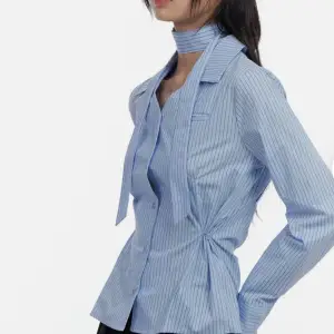 Säljer en superfin blå randig blus från Koreanska med knytband runt halsen. Den har långa ärmar och en snygg passform som ger en elegant look. Perfekt för både vardag och fest! 💙Model is wearing size S/M and the color Blue.  Height : 5'5