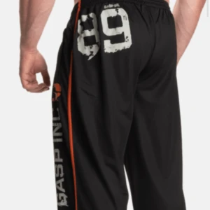 Svarta träningsbyxor från GASP - Säljer ett par svarta träningsbyxor från GASP med tryck i vitt och orange längs benet. Byxorna har en loose passform och elastisk midja med snörning för extra komfort. Perfekta för gymmet eller avslappnade dagar. Stor logga och nummerdetalj ger en sportig look. St S. Fråga om ni vill ha fler bilder. 