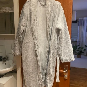 Mysig grå morgonrock - Säljer en supermysig grå morgonrock perfekt för att mysa runt hemma. Den har långa ärmar och är i ett mjukt och skönt material. Passar både höst och vinter. 🛁 ONESIZE
