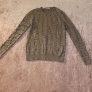 Beige stickad tröja - Säljer en snygg beige stickad tröja i mycket bra skick. Den har ett klassiskt flätmönster och långa ärmar. Perfekt för höst och vinter, och den är supermysig att ha på sig. Passar både till vardags och lite finare tillfällen. 🧶✨