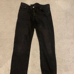 Svarta jeans från H&M - Säljer ett par svarta jeans från H&M i straight regular fit. De är i bra skick och passar perfekt för vardag. Klassisk design med fem fickor och knappgylf. Perfekta för höst och vinter! Knappt använda
