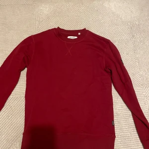 Röd tröja från Strömberg Ullared - Säljer en snygg röd tröja från Strömberg i storlek M. Den är gjord av fin bomull och har en enkel design med långa ärmar. Perfekt för både vardag och lite kyligare dagar. Passar bra till jeans eller chinos!