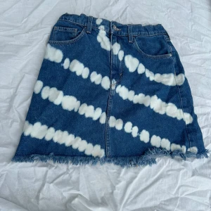 Blå jeanskjol med batikmönster - Säljer en supercool blå jeanskjol från Zara med ett unikt vitt batikmönster. Kjolen har en rå kant nertill och klassiska femficksdetaljer. Perfekt för en avslappnad sommarlook eller festival! 🦋kjolen är använd endast några få gånger så därav i väldigt bra skick💕